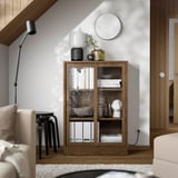 Wooden bookcase with glass doors in living room, minimalist.