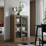 Wooden display cabinet with glass doors showing dishes, a vase, and decor items.