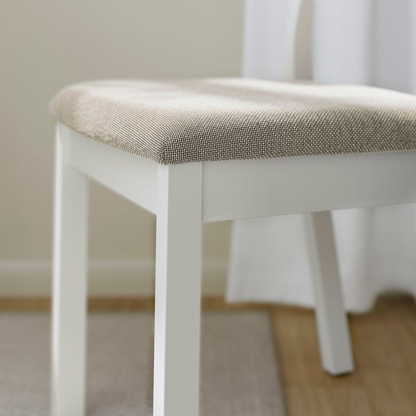 Modern dining chair with rounded design, white frame, and padded seat. Soft fabric in a textured pattern offers comfort.