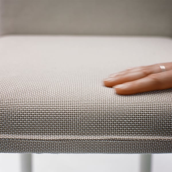 Hand rests on TONSTAD table, showcasing smooth, woven texture and sturdy build quality.