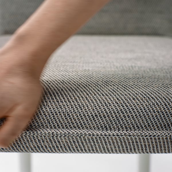Close-up of hand on a TONSTAD fabric chair, showcasing soft, textured, high-quality material.