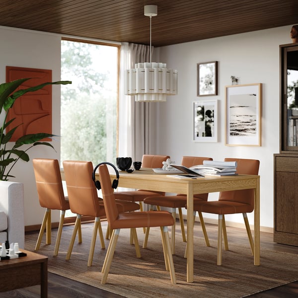 Modern oak dining set with 6 chairs, pendant light, decor.