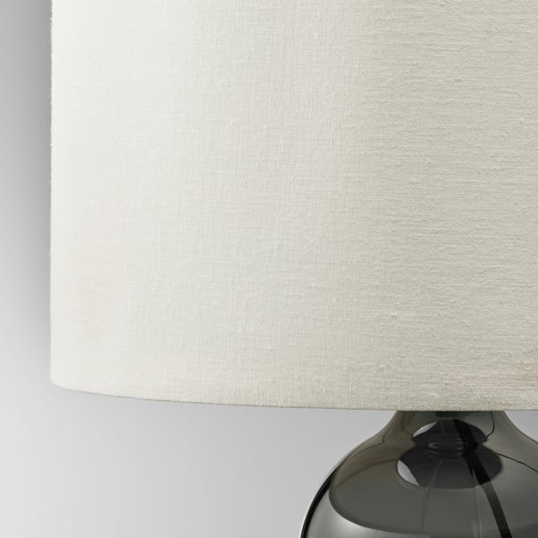 Modern lamp with smoky glass base and sleek beige shade. Quality craftsmanship evident in glass and fabric.