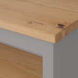 Close-up of rustic wooden tabletop with visible grain and natural patterns, supported by metal legs.