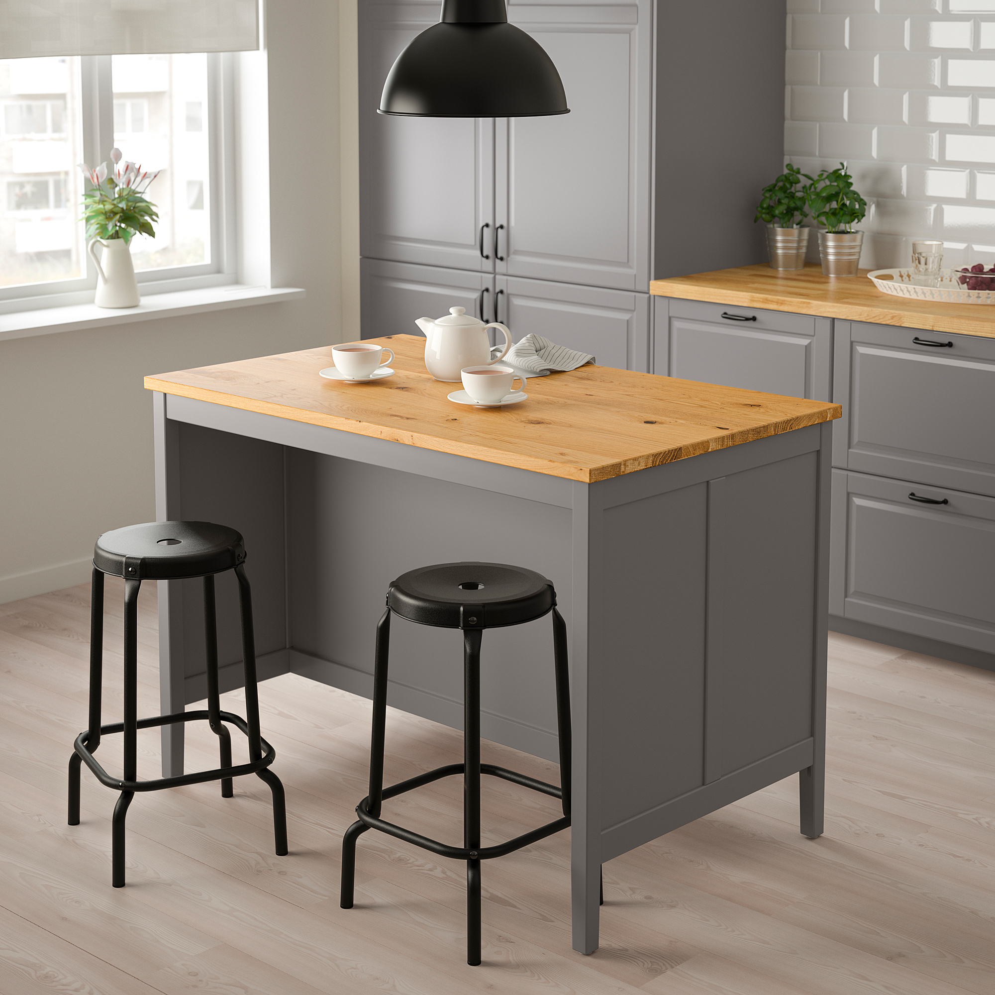 Grey TORNVIKEN kitchen island with oak top and black stools.