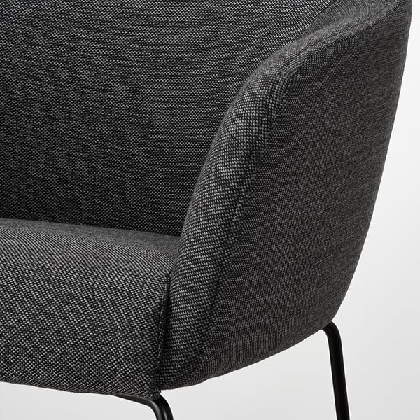 Dark gray upholstered barstool detail, showcasing plush fabric and sleek metal leg.