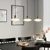 Smart bulbs above dining table, warm glow, modern decor with art, flowers.