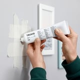 Applying TRIXIG wall repair filler to small hole.
