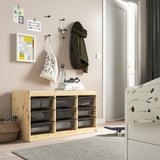 TROFAST storage unit with mesh boxes in beige next to a crib, featuring a light wood frame, ideal for kids’ room.
