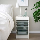 TROFAST: white bedside storage with mesh drawers. Plant, lamp, and water bottle nearby.