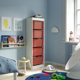 Childrens room with TROFAST red storage, light blue walls, white furniture, space-themed decor, and toys.