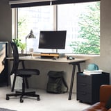 Modern home office setup with black TROTTEN desk, chair, and storage units; minimalist design.