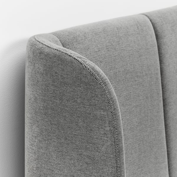 Close-up of upholstered beds curved headboard, showcasing fine stitching and soft gray fabric, emphasizing comfort and quality.