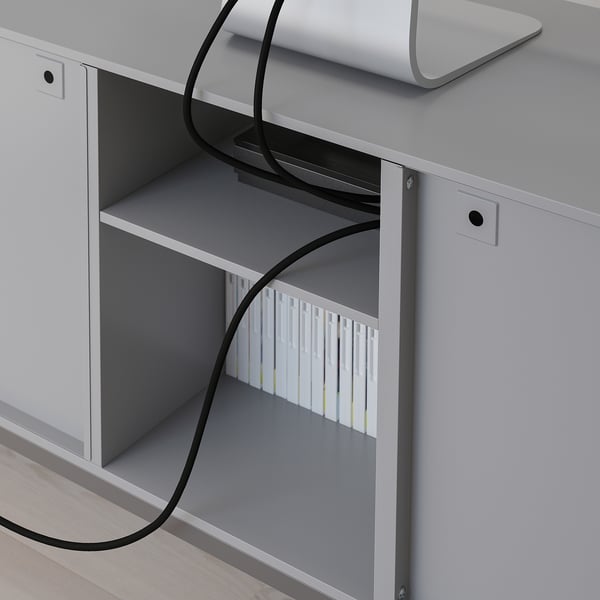 A TULLSTORP tv bench with metal bevelled doors and cable management at the back, designed for organizing tv accessories.