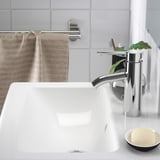 A sleek, modern sink with a shiny chrome faucet, featuring a deep bowl to prevent splashes, and a soap dish nearby.