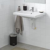 Modern bathroom with TVÄLLEN white sink, silver tap, gray towel, black bin, clean tiled wall.