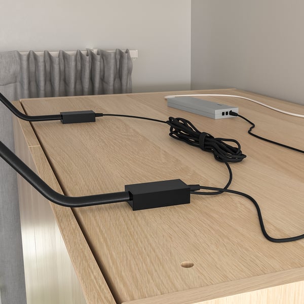 Wooden surface with two black rectangular led lights and connected wires.