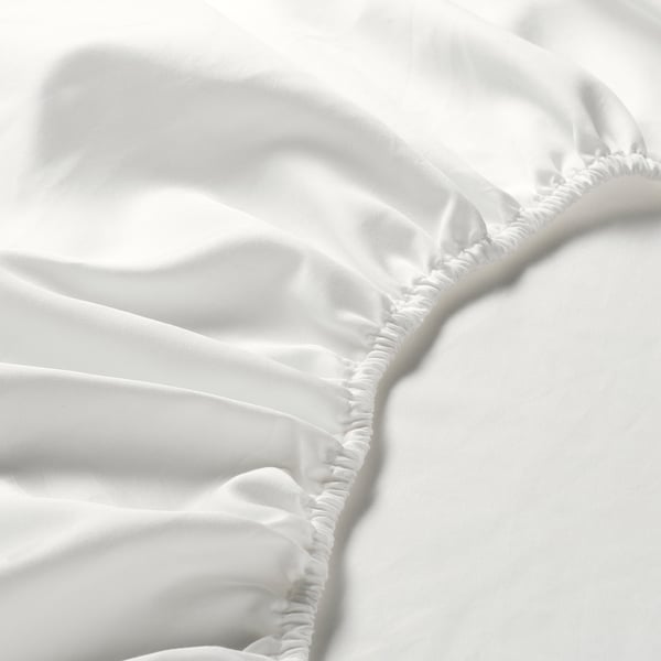 Closeup of smooth, white, high-thread-count bed sheet, showcasing fine stitching and soft texture.
