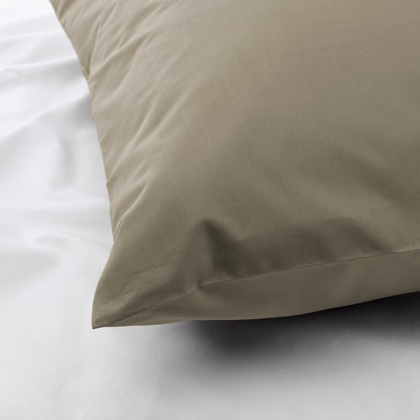 Close-up of a crisp, beige pillowcase on a white sheet, showcasing its smooth texture and high-quality fabric.