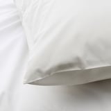 Close-up of crisp, white pillowcase with smooth, high-quality fabric.