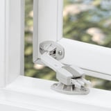 White window catch device holding window open, with screws visible.