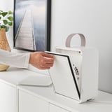 Person handling a white air purifier on a white dresser, showing an easy-to-remove filter.