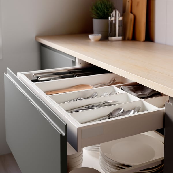 Open kitchen drawer showing UPPDATERA cutlery organizer with neatly arranged utensils, keeping items visible and accessible.