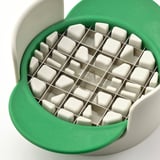 Green and white fruit cutter with stainless steel blades, arranged in a grid pattern, on a white background.