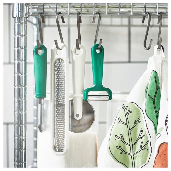 Kitchen tools: peeler, grater, cutter, cloth with leaf design.