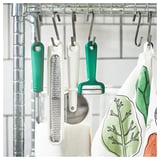 Kitchen tools: peeler, grater, cutter, cloth with leaf design.
