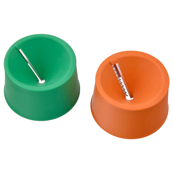 Two colored cylindrical kitchen tools side-by-side; green and orange, each with a horizontal blade slot.