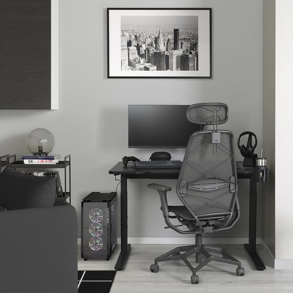 UTMANING desk setup with monitor, chair, and accessories under city photo.