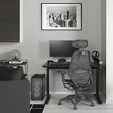 UTMANING desk setup with monitor, chair, and accessories under city photo.