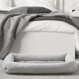 A cozy dog bed, UTSÅDD, a bolstered edge for support and relaxation. The soft, machine-washable cover is perfect for indoor pets.