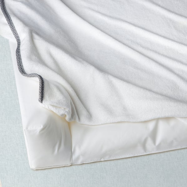 White baby changing cover with gray trim, soft and comfortable for diaper changes.