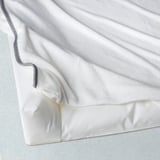 White baby changing cover with gray trim, soft and comfortable for diaper changes.