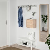 Small VÄLJARE cabinet: white, wicker design, wood material, wall-mounted, storing items. Positioned under a hat rack, reflecting in a large mirror.