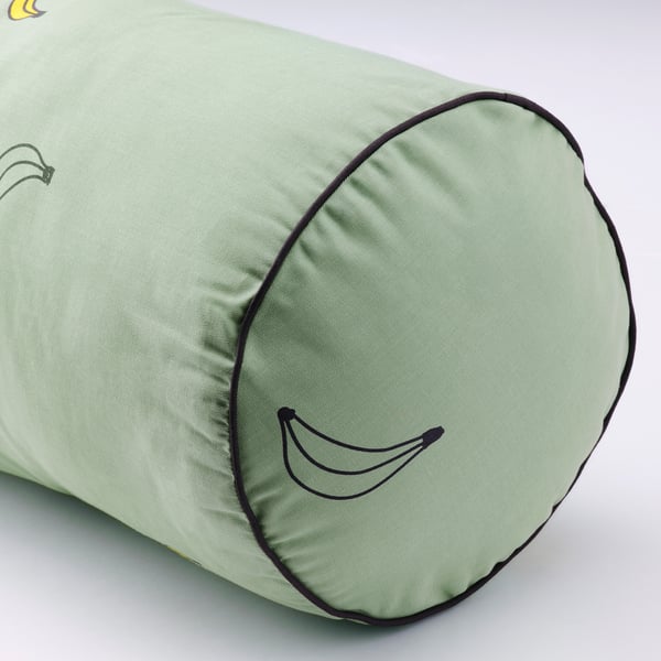 Green cylindrical pillow with black smiley face, high stitching quality, smooth fabric, zipper detail.