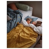 Two children sleeping in bed with VÄNKRETS blue banana-print duvet, yellow cover, and pillows.
