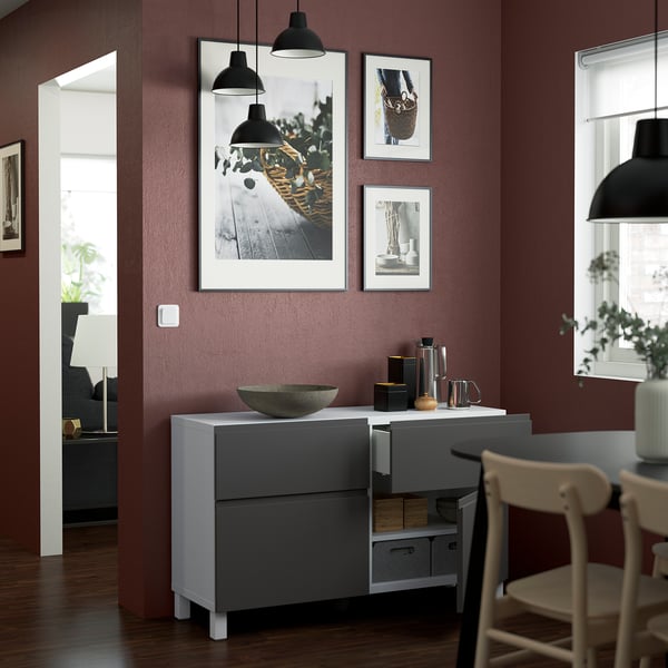 Modern sideboard with handles, drawers, and minimalist design. Includes bowl and decor.