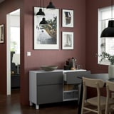 Modern sideboard with handles, drawers, and minimalist design. Includes bowl and decor.
