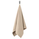 A beige VÅGSJÖN cotton towel hangs neatly folded on a hook.