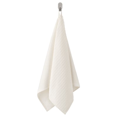 A VÅGSJÖN white hand towel hanging from a hook. Its rectangular, made of 100% cotton, with a textured surface.
