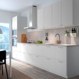 Modern kitchen with white cabinets, stainless steel appliances, and gray countertop. VALLSTENA cabinets dominate space.