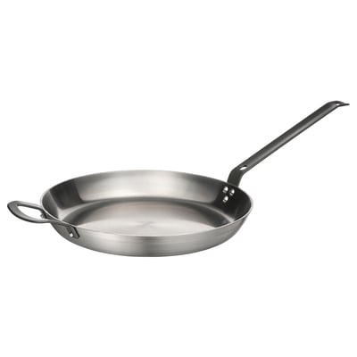 A VARDAGEN carbon steel frying pan with black handles. Its round, shiny, and has a sloped handle for balance.