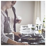 Cooking together with VARDAGEN pan, wine, and plants.