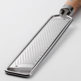 Stainless steel grater with wooden handle, hanging hole for storage.