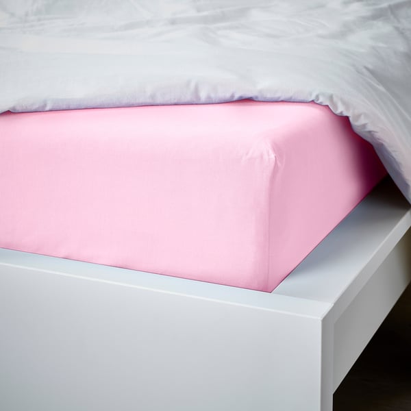 Bed with pink fitted sheet on white frame.