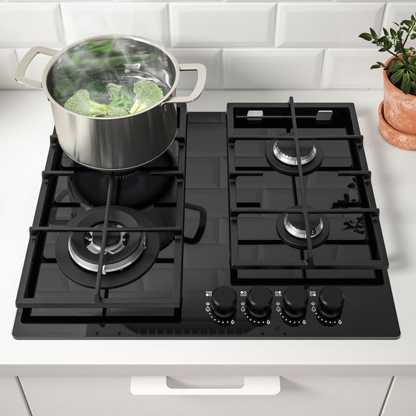 Modern kitchen with VASASTAN gas hob cooking green veggies.