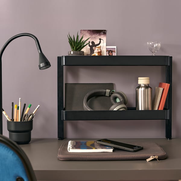 Black VATTENKAR desk organizer with headphones, water bottle, lamp, and pen holder.